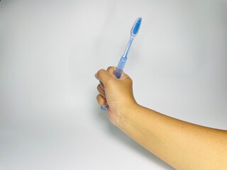 hand is picking up a toothbrush, Handheld toothbrush for daily dental hygiene routine and oral...