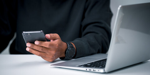 A middle-aged man holds a smartphone in his hand for various transactions such as paying for products online, shopping online, checking information, and more.