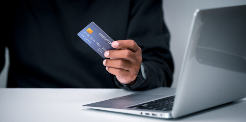 Credit card spending. Middle-aged man holding credit card in hand for paying for online products, online shopping.