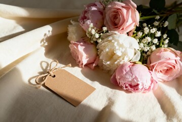 Mother’s Day bouquet with blank gift tag on soft fabric, perfect for holiday promotions, greeting...