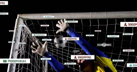 Leaping keeper in blue jersey reaching for black-and-white ball at goal, showing gloves, overlays