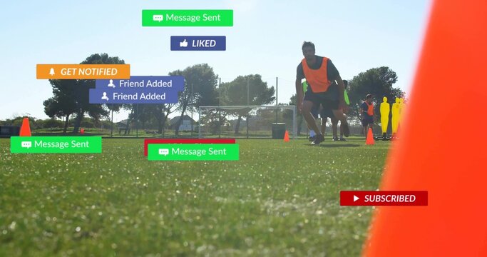 Training soccer players in orange bibs running through cones on grass, social alerts, copy space - Powered by Adobe