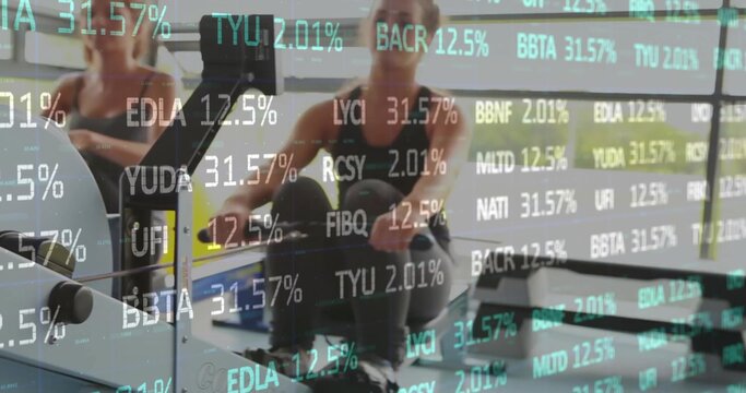 Rowing women pulling handles on ergometers in gym, in dark athletic wear with green ticker overlay