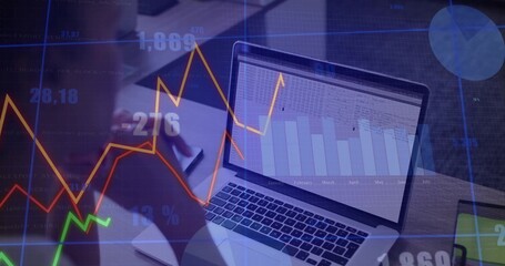 Writing woman in light blouse noting on notepad at desk, with laptop, pen, financial overlays