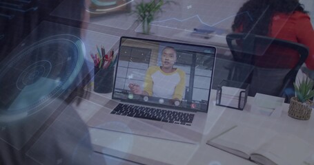 Showing laptop with onscreen host in yellow raglan speaking at office HUD graphics and red-top team