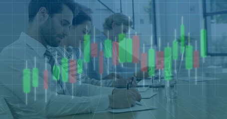 Writing team wearing business attire reviewing papers at meeting, using laptop with chart overlay