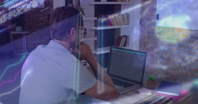 Working middle-aged man wearing eyeglasses light tee typing on laptop at home with data overlays