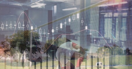 Kneeling male soccer player in white kit red socks handling ball near goal net, with charts
