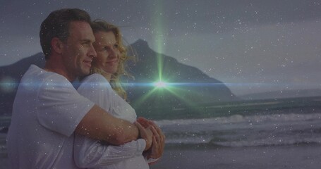 Naklejka premium Embracing couple wearing white shirts, gazing at dusk horizon on beach with waves, ridge, flare