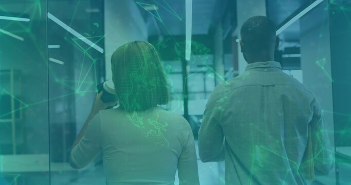 Walking pair in longsleeve light shirt down glass hall holding paper cup slim folder green overlay