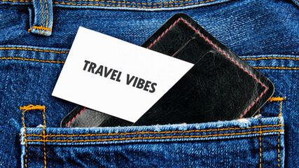 A stylish wallet nestled in the pocket of blue denim jeans, showcasing a card that reads travel vibes. This simple yet impactful scene evokes a sense of adventure and wanderlust