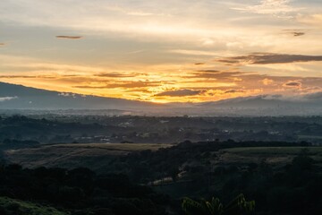Dawn breaking over a tranquil landscape with soft clouds and distant mountains in the early hours of the morning