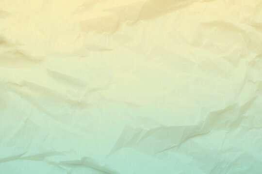 Wrinkled paper surface features a gentle gradient color transition from warm yellow to soft green, creating a textured background suitable for design projects or digital art.