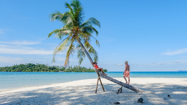 Relaxing at koh kood islands tranquil beach with vibrant palm trees and crystal clear waters