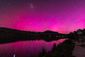 Aurora Australis display lights up the sky in pinks over the dam