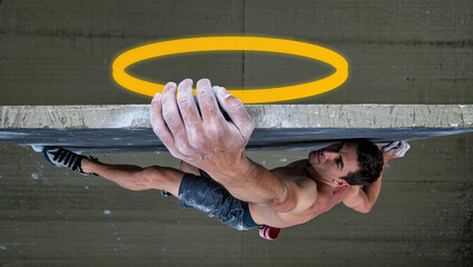 Conceptual image of athletic rock climber hanging from wall with yellow halo symbol, metaphor of strength, focus, determination and human potential.