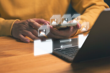 Person holding a smartphone with digital image file icon and a folder graphic between the phone and...