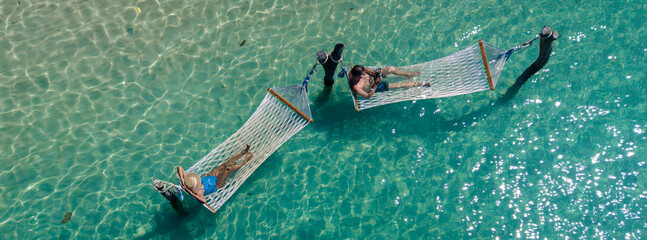 Relaxation on hammocks in the crystal clear waters of Koh Kood Island Thailand