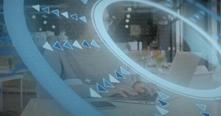 Man typing laptop in cafe, causing rotating blue overlay arrows marking phone and editing tech doc