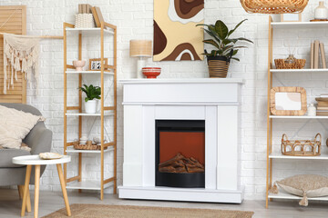 Naklejka premium Interior of modern living room with fireplace, shelving units and armchair