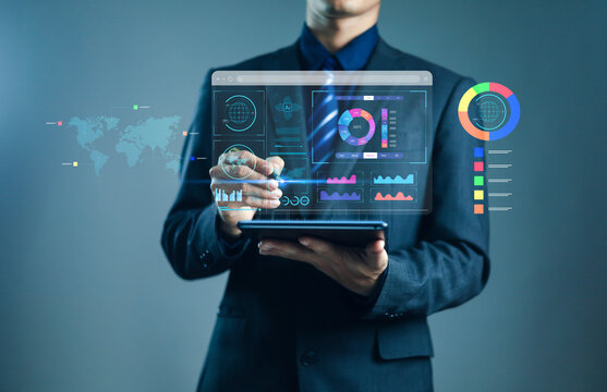 Businessman using digital tablet with virtual data analytics dashboard and futuristic hologram charts. Concept of artificial intelligence, big data, finance analysis.