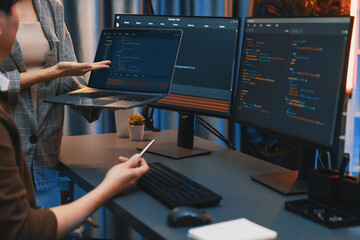 Serious of IT developers discussing intelligent website development coder system running data online two screens with laptop showing information network at neon light room at modern office. Infobahn.