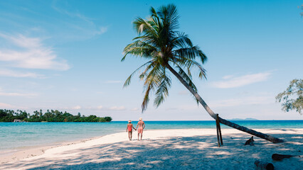 Strolling along the pristine shores of Koh Kood Island, Thailand under a clear blue sky