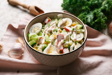 Bowl of salad with crab sticks, iceberg leaves, corn, cucumber and quail eggs, closeup
