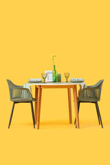 Served restaurant table with flower on yellow background
