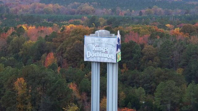Thank you for visiting kings dominion amusement center in doswell, Virginia. Aerial view. Multi-colored trees on cloudy day in fall season. Wide shot.