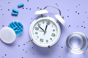 Melatonin pills with glass of water, alarm clock and confetti on purple background