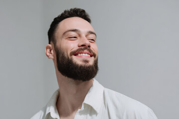 closeup of bearded man face exuding emotion and effort while smiling broadly