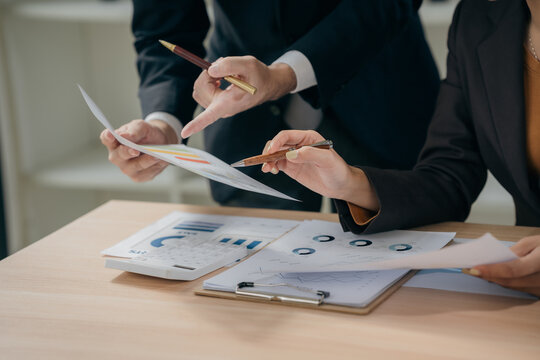 Business people discussing charts and graphs showing results of teamwork in a meeting to analyze financial reports, planning strategies, success.