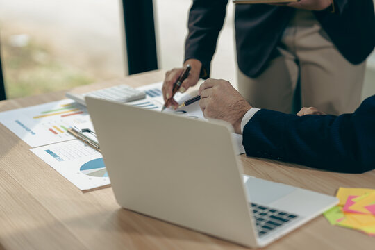 Business people discussing charts and graphs showing results of teamwork in a meeting to analyze financial reports, planning strategies, success. - Powered by Adobe