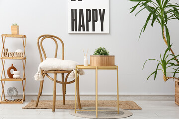 Interior of light room with chair, table and plant in basket