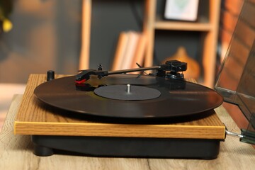 Modern turntable with vinyl record at home, closeup