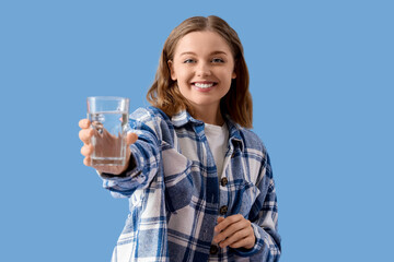 Young woman with glass of water on  blue background