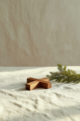 wooden cross lies gently on linen tablecloth accompanied by sprig of fir