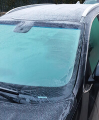 Car windshield and roof covered in thick frost in winter