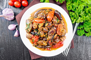 Eggplants with champignons in plate on dark board top