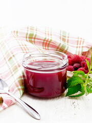 Jam of raspberry in jar on wooden board