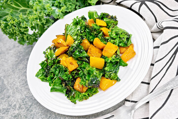 Kale with pumpkin in plate on granite countertop