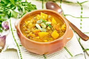 Soup-curry with pumpkin and lentils in bowl on towel