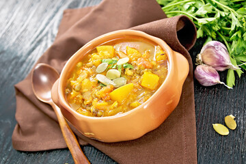 Soup-curry with pumpkin and lentils in bowl on wooden board