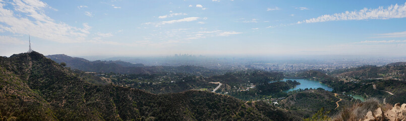 Obraz premium Panorama of the skyline of Los Angeles as seen from the Wonder View Trailhead to Wisdom Tree on Cahuenga Peak during a summer season in Los Angeles, California, USA