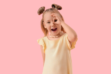 Cute little girl with imaginary telescope on pink background