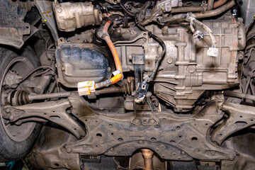 Undercarriage view of front vehicle section showing suspension, drivetrain, transmission and oil...