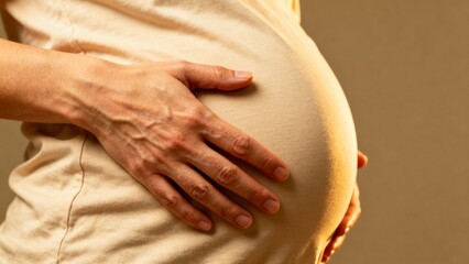 close view of a woman holding her pregnant belly