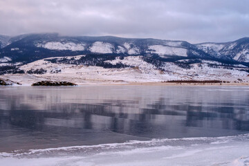 Baikal Lake in winter. Beautiful landscape with mountains reflected in ice of frozen Small Sea