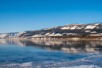 Baikal Lake in winter. Beautiful landscape with mountains reflected in ice of frozen Small Sea